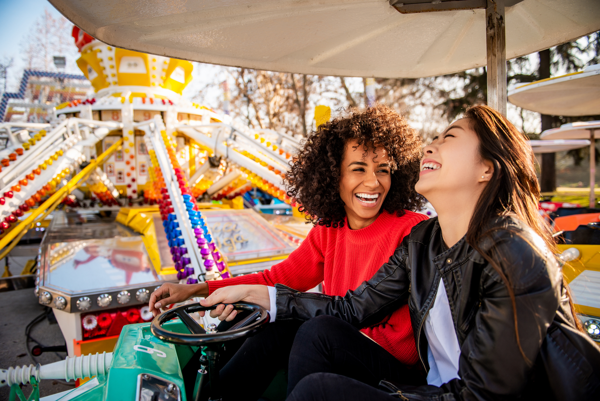 women laughing on amusement park ride